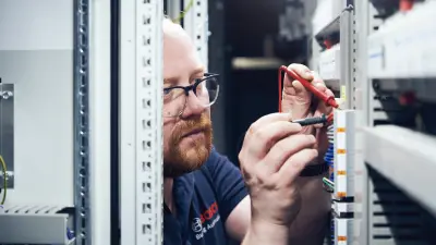 Marco Krause at work in a control cabinet during a customer project at Kaiserslautern University of Applied Sciences.