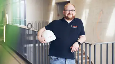 Marco Krause stands in New Building H on the campus of Kaiserslautern University with a construction helmet under his arm.