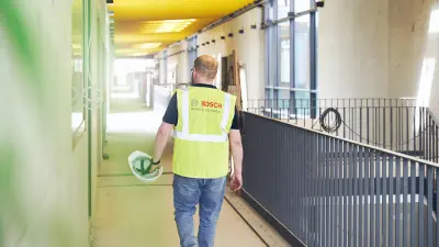 Rear view of Marco Krause walking down a corridor in a building at Kaiserslautern University of Applied Sciences.