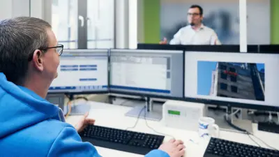 Matthias Hildebrandt, Shift Manager at Bosch emergency call and service control center Magdeburg, Germany, at his working station with headseat and three screens