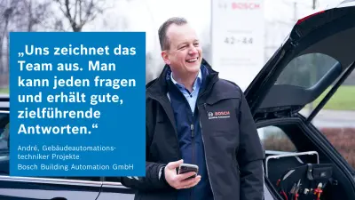 Mitarbeiter am Auto lächelt einem Kollegen zu