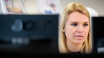 Sabrina Ruis at work in the office at two computer screens