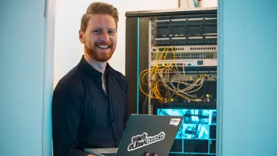 Servicetechniker von Bosch mit Laptop vor Sicherheitstechnik