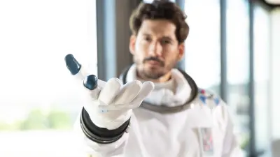 Datanaut stretching out hand their hand with the palm upward to the observer – as visualization of the creation of building digital twins with Building Digital Twins