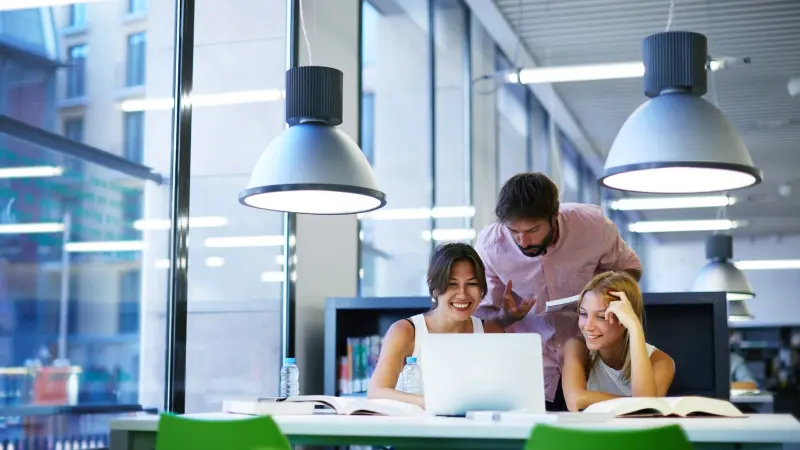 Drei Personen lernen an einem Laptop
