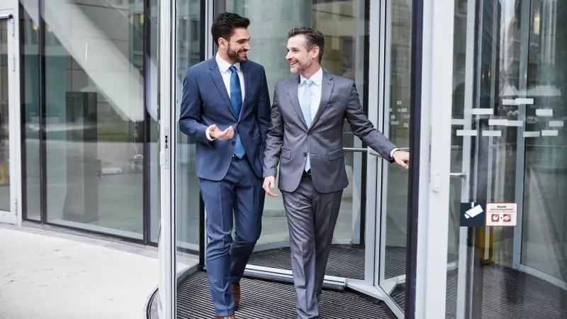 Zwei Männer verlassen ein Gebäude