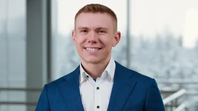 Branchenmanager Thomas Jörg steht im Anzug angelehnt an einem Geländer.