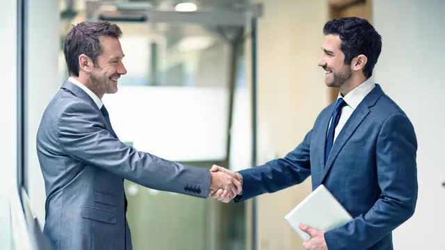 Zwei Männer begrüßen sich.