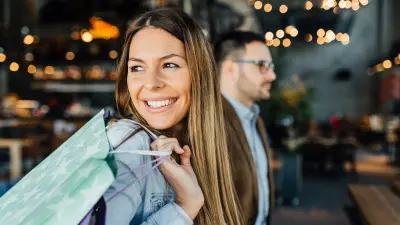 woman with a shopping bag and a man in the background