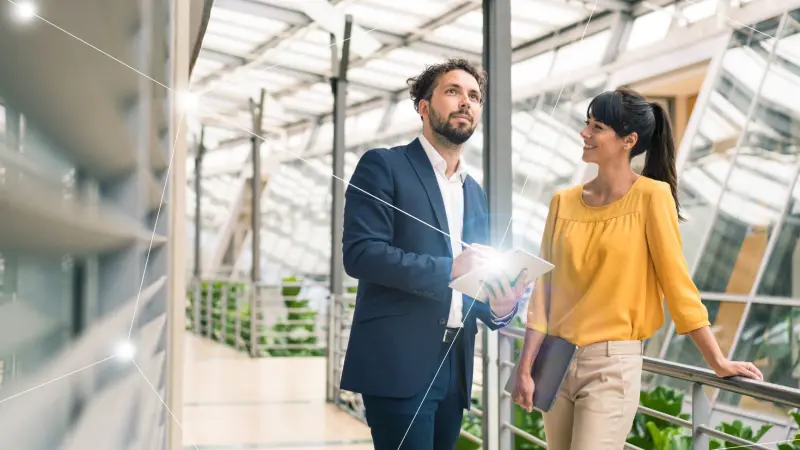 Man and woman sitting together at a desk working in a connected building from Bosch Energy and Building Solutions 