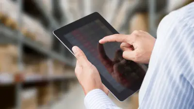 Male hand holding tablet and operating building management system