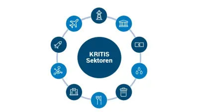 Mann mit Brille und Kaffeetasse sitzt fröhlich vor PC