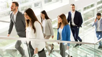 People walking up stairs in an office building with connected solutions from Climatec and Bosch