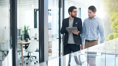 Zwei Männer laufen durch klimaneutrales Unternehmen von Bosch Energy and Building Solutions