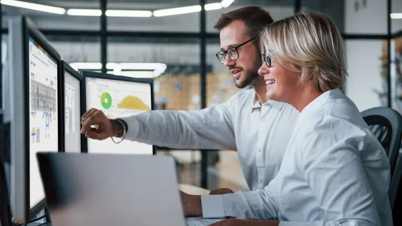 Two persons looking at different Screens with company dashboards of our Bosch Services Smarter Betrieb 