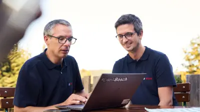 Bosch associates in front of the laptop outdoors