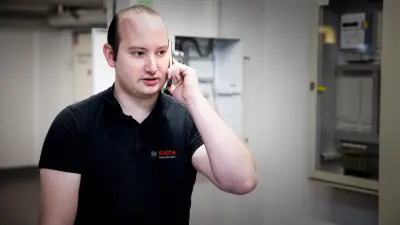 Bosch Servicetechniker Kevin Wilhelm telefoniert mit Kunden
