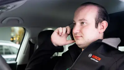 Service technician Kevin Wilhelm talking on the phone in his company car