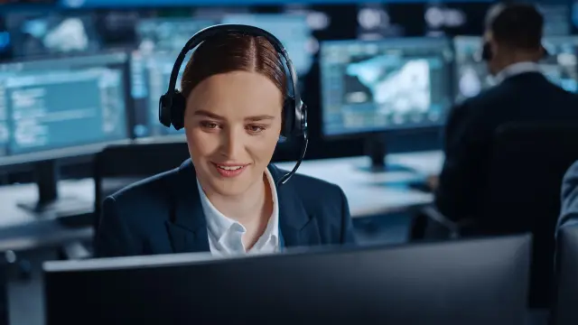 Frau mit Headset vor einem Bildschirm