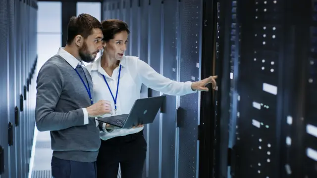 Mann und Frau vor Großrechner