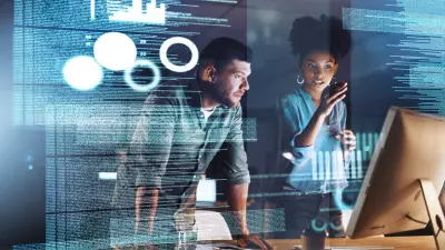 Zwei Kollegen sprechen und schauen auf einen Computerbildschirm mit Ontologien