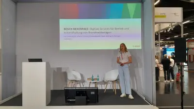 Ines Schittenhelm von Bosch Energy and Building Solutions bei einer Präsentation der NEXOSPACE Services auf einer Bühne