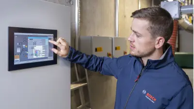 Felix Böttcher from Bosch in front of the display control unit at Sozialwerk Am Bruckwald