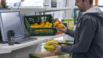 Employee fills a box with fruit