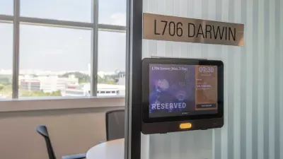 A tablet next to the door of the meeting room shows when the room is occupied and by whom.