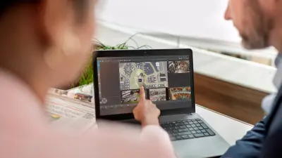 Two people watching monitor of a notebook with video sequences