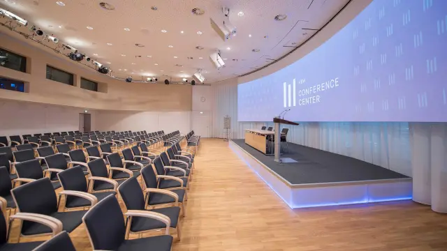 Leere Stuhlreihen vor einem Podium im Conference Center