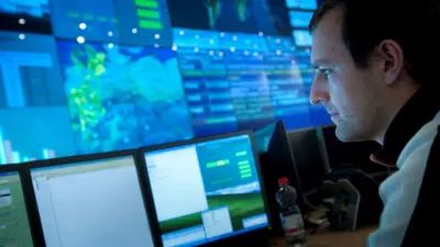 Mitarbeiter vor Bildschirmen im Rechenzentrum