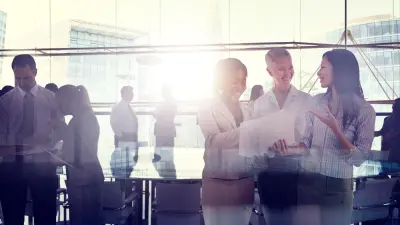 Men and women in an office standing and talking