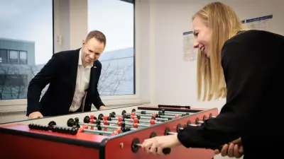 Spaß im Büro: Björn Kockrick beim Kickern/Tischfußball mit einer Kollegin