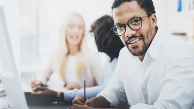 Lernen in Gruppen. Gruppenarbeit mit 2 Frauen und einem Mann. Freude an der Arbeit.