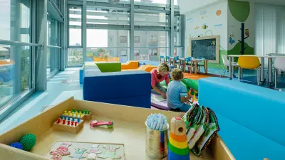 A child and a woman are playing in a room with toys
