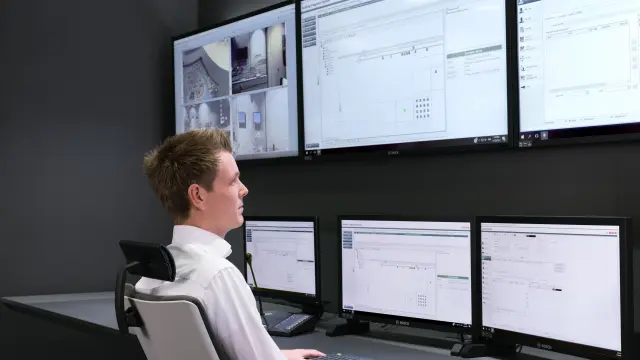 Strażnik ochrony oglądający obraz z kamer w sterowni