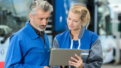Woman shows man something on tablet