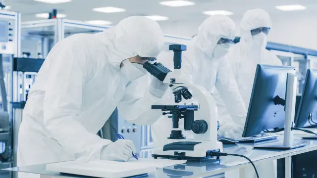 Employees in protective suits in clean room