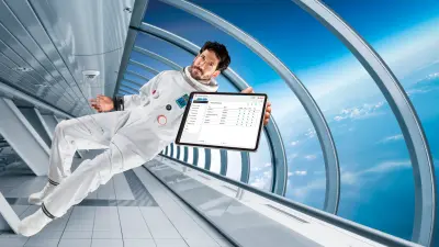 Hombre y mujer vestidos con ropa de trabajo mirando una tablet