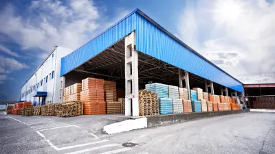 a half-open warehouse is full of stacked pallets