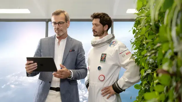 Ein Systemintegrator steht in seinem Büro und schaut auf sein Tablet, um seine Brandmeldesysteme über NEXOPSPACE Fire System Explorer zu überwachen