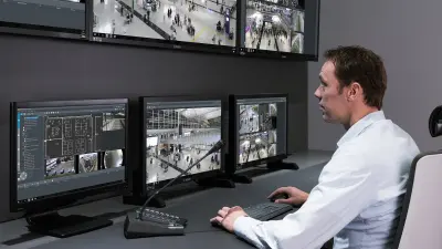 Control center officer sitting in front of monitoring screen with 24/7 intervention: Guard’n Go service from Bosch