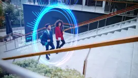 Two people walking up stairs to a building.